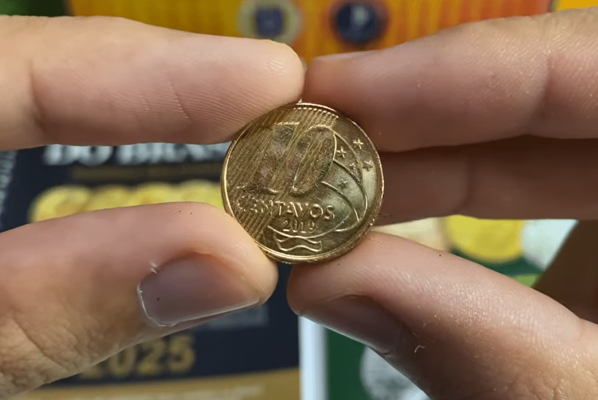 Moeda de 10 centavos brasileira em mãos - Identificação de raridades Pessoa segurando moeda brasileira de 10 centavos de 2019 com detalhes visíveis do anverso
