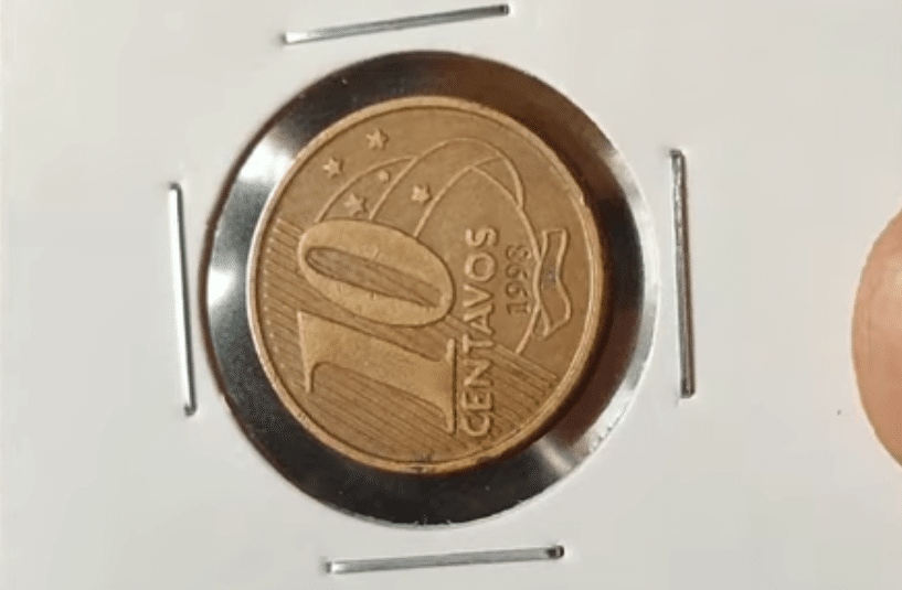 Reverso da moeda de 10 Centavos, datada de 1998, inserida em um suporte numismático. Imagem de referência para identificar o erro do reverso horizontal para a esquerda, um defeito raro e valioso procurado por colecionadores.
