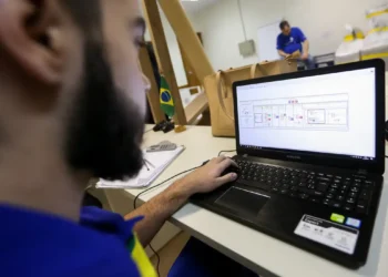 Homem observando fluxograma na tela de notebook Samsung em ambiente de escritório