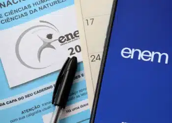 Imagem do ENEM 2025 com material de inscrição e logotipo do exame na tela de um celular.