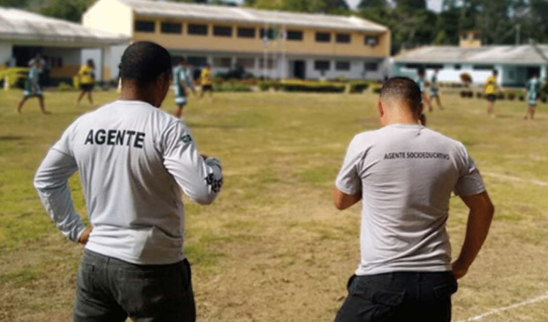 Agentes socioeducativos observando atividade em campo de unidade do IASES