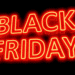 Letreiro em neon vermelho com as palavras “Black Friday” sobre fundo preto.