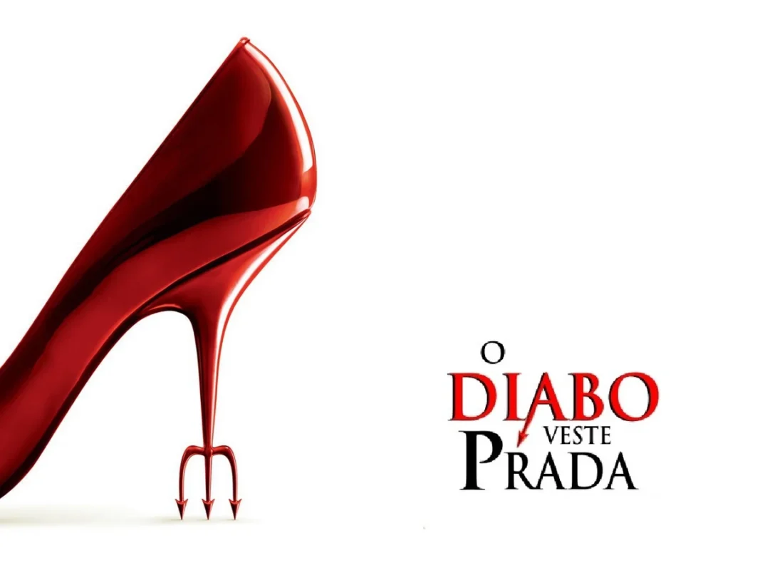 O Retorno de "O Diabo Veste Prada": O Estilo Inconfundível Continua. Salto alto vermelho elegante com o bico em forma de tridente, em fundo branco, sendo a logo do filme e simbolizando a icônica vilã Miranda Priestly e o estilo do filme "O Diabo Veste Prada".