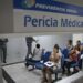 Fila de pessoas aguardando atendimento para perícia médica no INSS durante mutirão nacional.