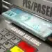 Notas de cem reais saindo de caixa eletrônico com as palavras PIS/PASEP e Abono Salarial destacadas.
