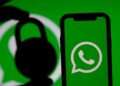 Smartphone com logotipo do WhatsApp em tela verde, com silhueta de cadeado ao lado, simbolizando a vulnerabilidade de segurança e bloqueio de dados com o vazemento de dados do whatsapp.