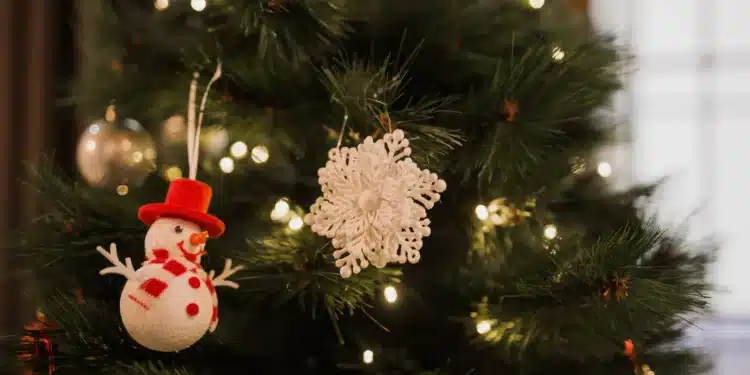 Imagem de uma árvore de Natal tradicional com enfeites e luzes de Natal.