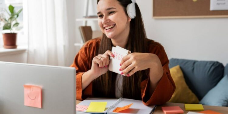 Jovem sorridente em videochamada, usando fones de ouvido, mostrando flashcard com números, simbolizando trabalho remoto.