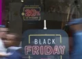 Letreiro luminoso anunciando Black Friday com desconto de 20% em loja com movimento de pessoas