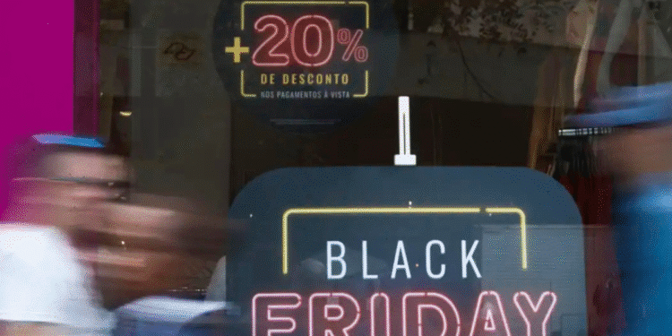 Letreiro em vitrine anunciando Black Friday com desconto adicional de 20% em peças remarcadas para pagamento à vista