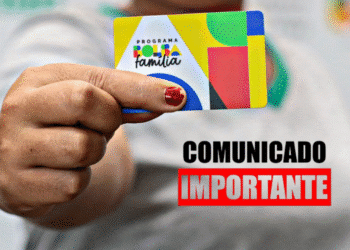 Pessoa segurando o cartão do Bolsa Família com aviso de “Comunicado Importante”.