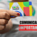 Pessoa segurando o cartão do Bolsa Família com aviso de “Comunicado Importante”.