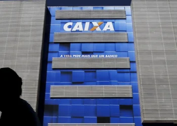 Fachada azul com o logo da Caixa Econômica Federal e frase "A vida pede mais que um banco" em destaque