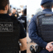 Imagem de um policial civil e guarda municipal de costas.