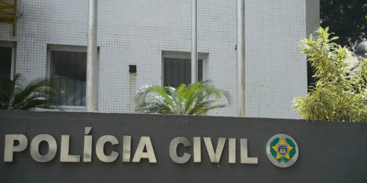 Fachada da Polícia Civil com letras metálicas e símbolo oficial em uma parede cinza