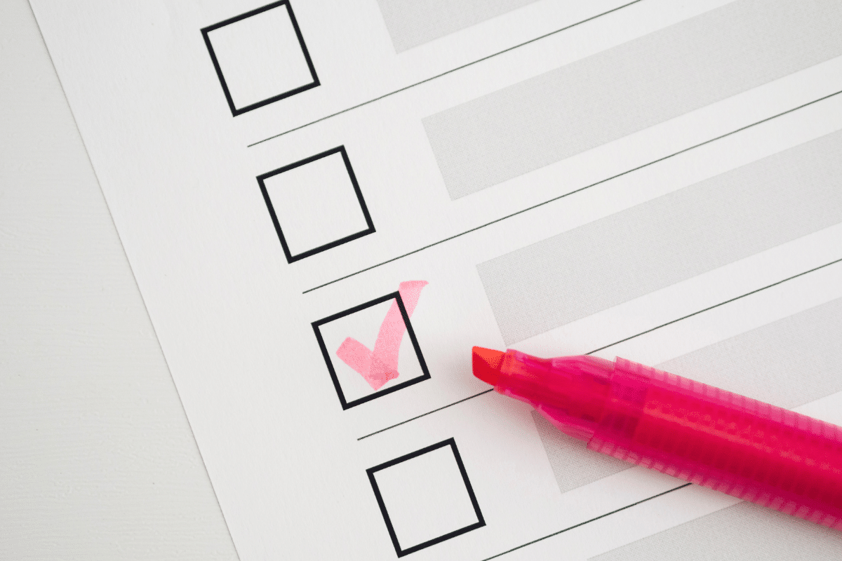 Formulário com caixas para marcar, uma delas assinalada com caneta marca texto rosa