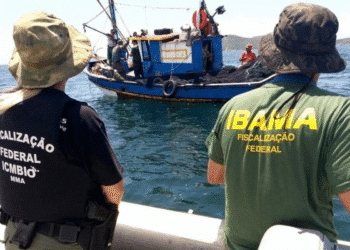 Agentes federais do IBAMA e ICMBio em ação de fiscalização de pesca em barco no mar
