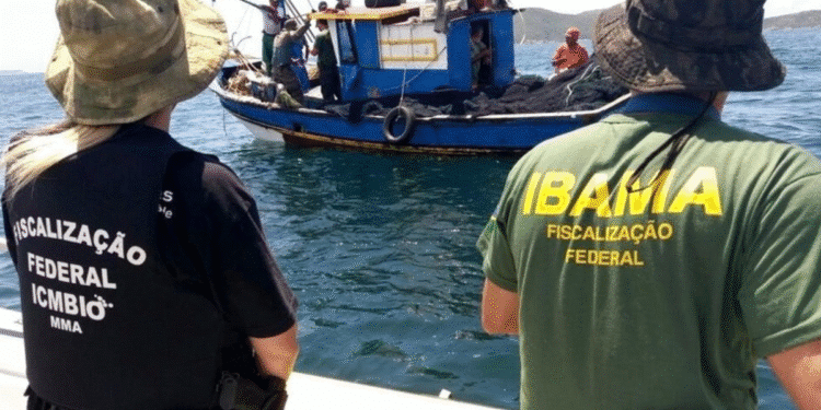 Agentes federais do IBAMA e ICMBio em ação de fiscalização de pesca em barco no mar