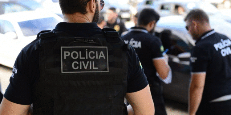 Policiais civis com coletes e uniformes em operação junto a carros estacionados na rua