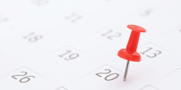Alfinete vermelho destacado no dia 20 de um calendário branco com números pretos