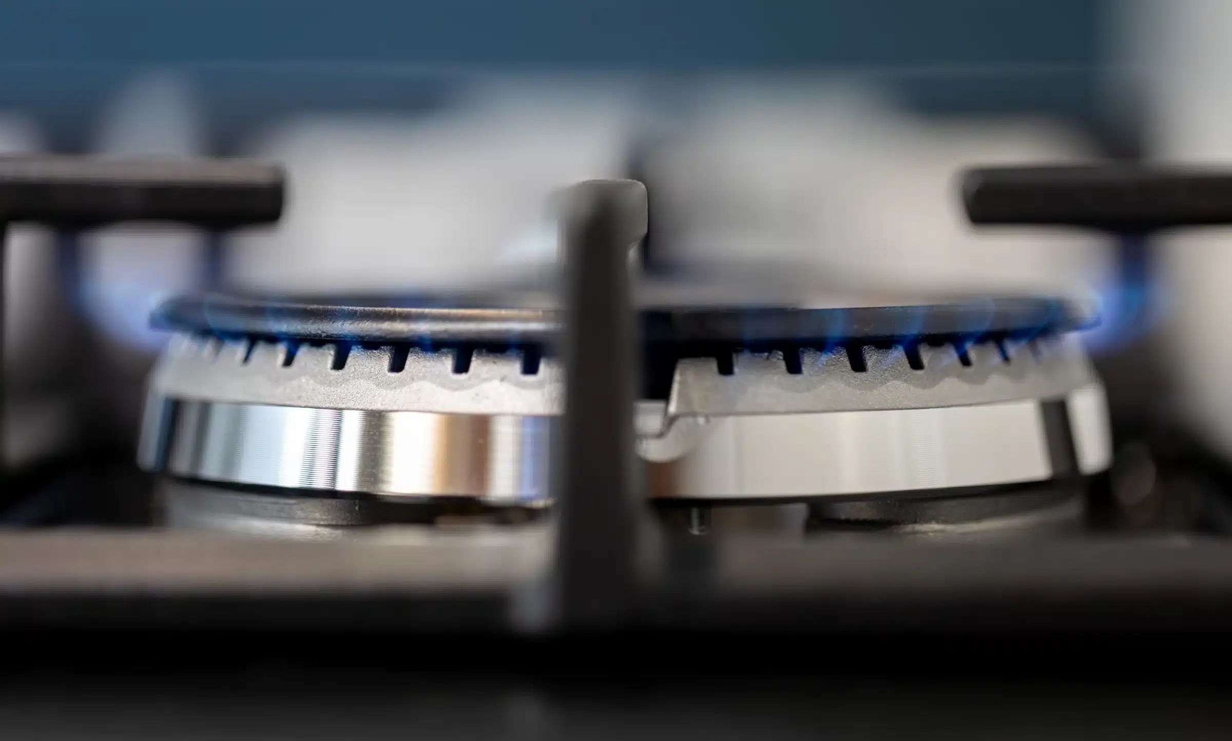 Redução do preço do gás para GNV e gás encanado Fogão a gás com chama azul, ilustrando o impacto da redução no preço do GNV e gás encanado.