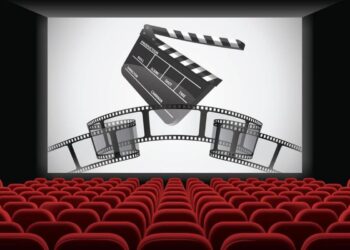 Cinema escuro com assentos vermelhos vazios, tela grande exibindo um claquete e rolos de filmes, simbolizando a nostalgia e o retorno das grandes sequências cinematográficas.