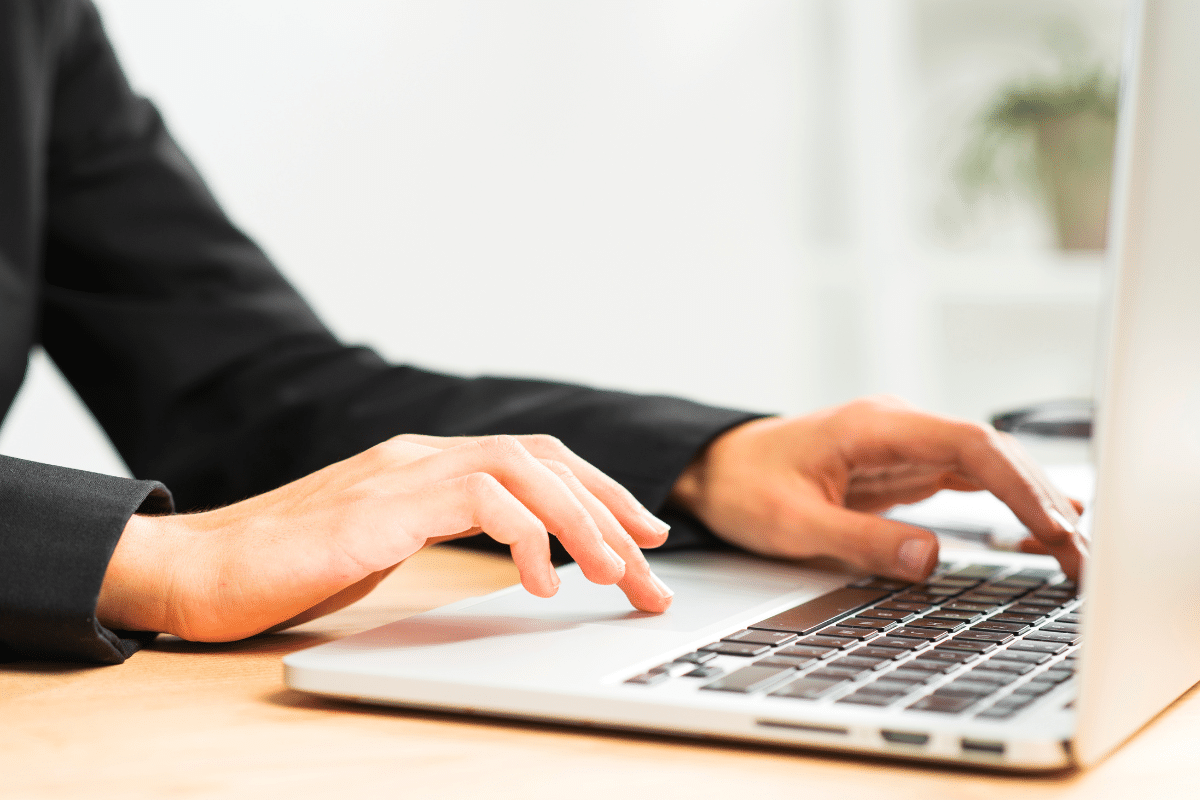 Inscrições concurso Mãos femininas digitando no teclado de laptop prateado sobre mesa de madeira clara