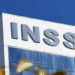 Fachada de prédio do INSS com letras em destaque na parte superior.