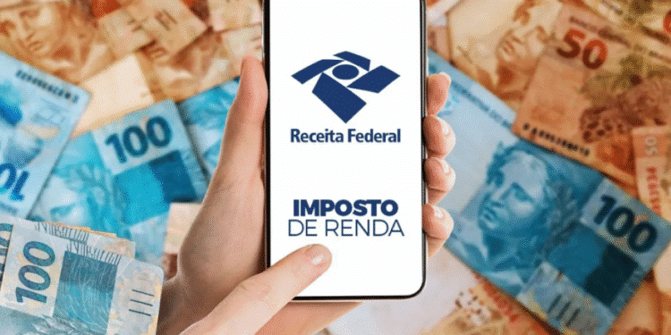 Mão segurando smartphone exibindo o aplicativo da Receita Federal para declaração de Imposto de Renda, com notas de real ao fundo.