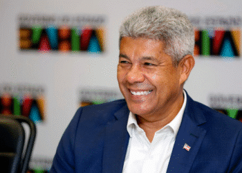 Governador Jerônimo Rodrigues sorrindo durante evento oficial com fundo escrito Governo da Bahia