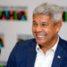 Governador Jerônimo Rodrigues sorrindo durante evento oficial com fundo escrito Governo da Bahia