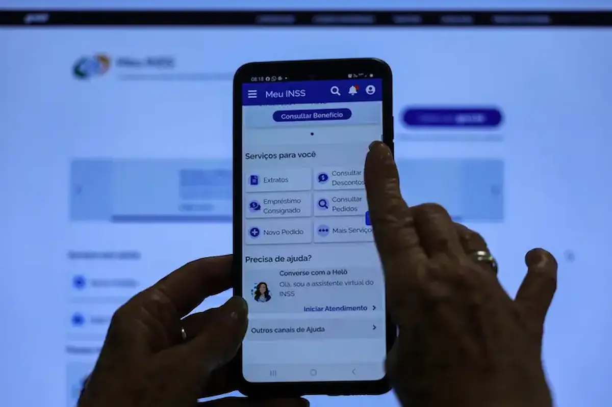 Pessoa utilizando o aplicativo Meu INSS para consultar o extrato de pagamento do benefício.