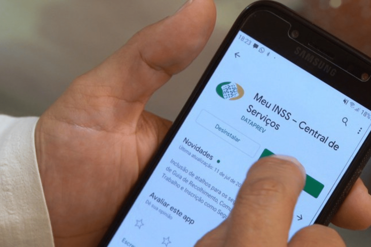 Pessoa usando celular com o aplicativo Meu INSS aberto na tela do Samsung.