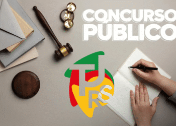 Mesa com martelo de juiz, cadernos, mãos escrevendo e logotipo do TJ-RS, representando concurso público.