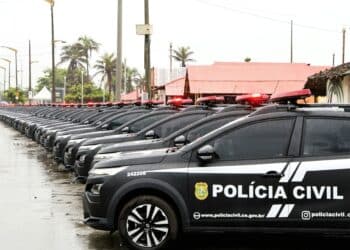 Diversos carros pretos da Polícia Civil do Ceará alinhados em fila sob chuva