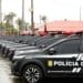 Diversos carros pretos da Polícia Civil do Ceará alinhados em fila sob chuva