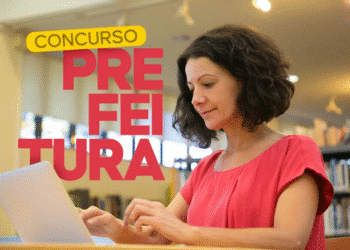 Mulher utiliza notebook com o texto “Concurso Prefeitura” ao fundo.