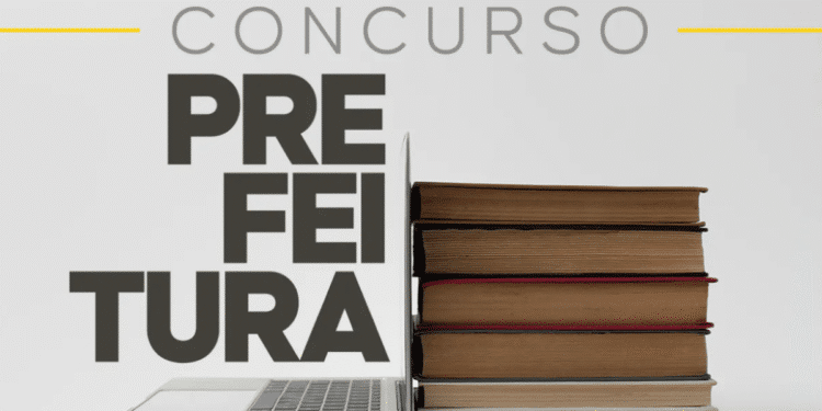 Laptop aberto encostado em uma pilha de livros fechados, com texto "CONCURSO PREFEITURA"