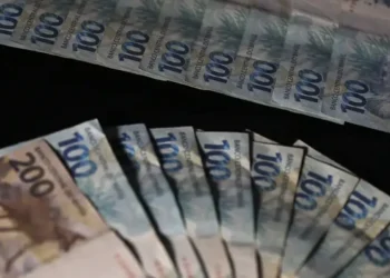 Notas de 100 e 200 reais representando valor da primeira parcela maior do 13º salário.