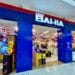 Entrada da loja Casas Bahia com decoração em azul, vermelho e branco, exibindo produtos eletrônicos em promoção