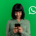 Mulher sorridente mexendo no celular com fundo verde e ícone do WhatsApp ao lado