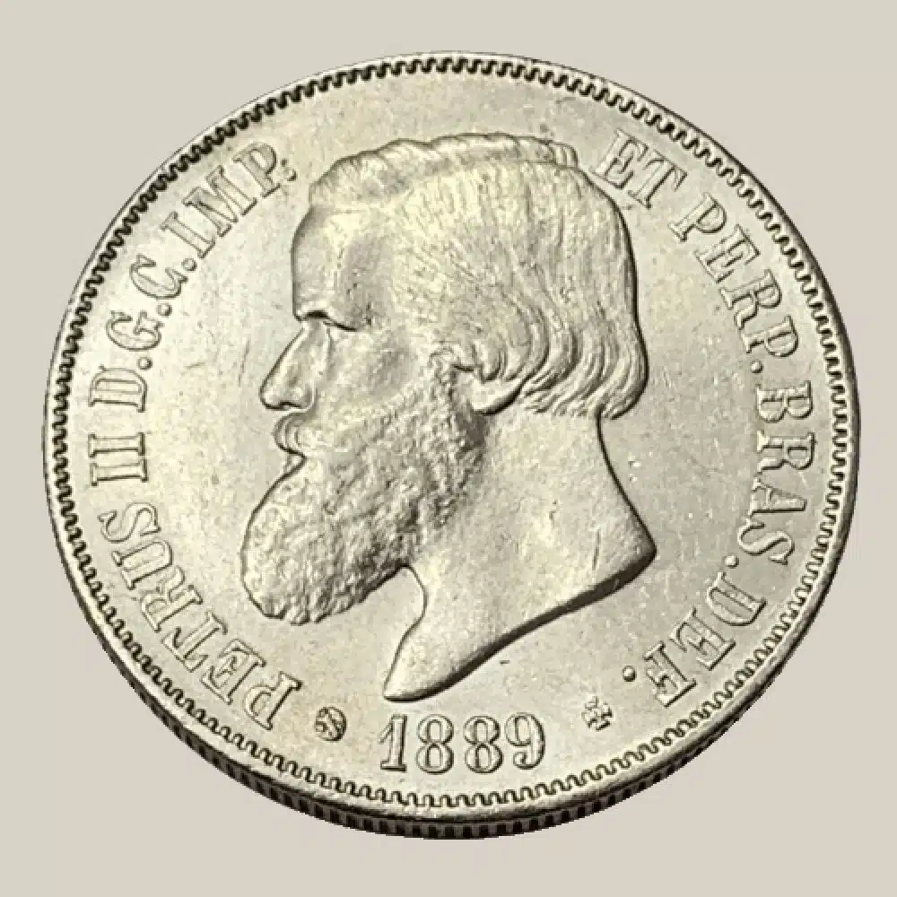 moeda 2000 reis 1889 prata dom pedro ii Anverso da moeda de prata de 2000 Réis do ano 1889, exibindo o busto de Dom Pedro II de perfil com barba, com legendas em latim ao redor.