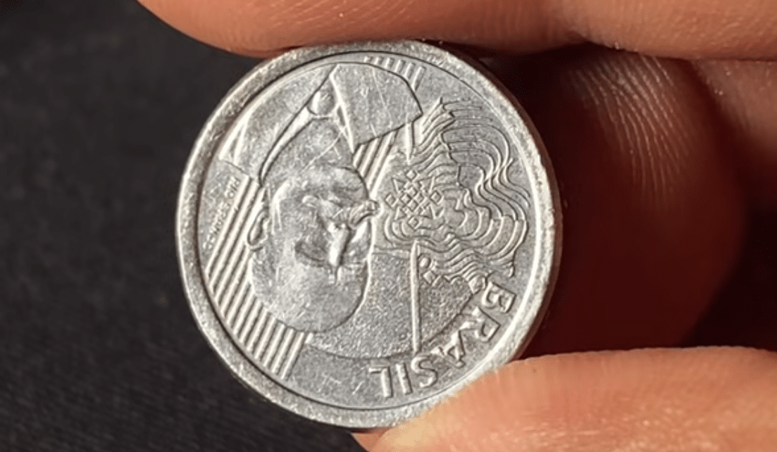 Close-up da moeda de 50 centavos, exibindo o busto do Barão do Rio Branco. A imagem ilustra o anverso da moeda que pode apresentar o erro de reverso invertido, elevando seu valor para colecionadores.