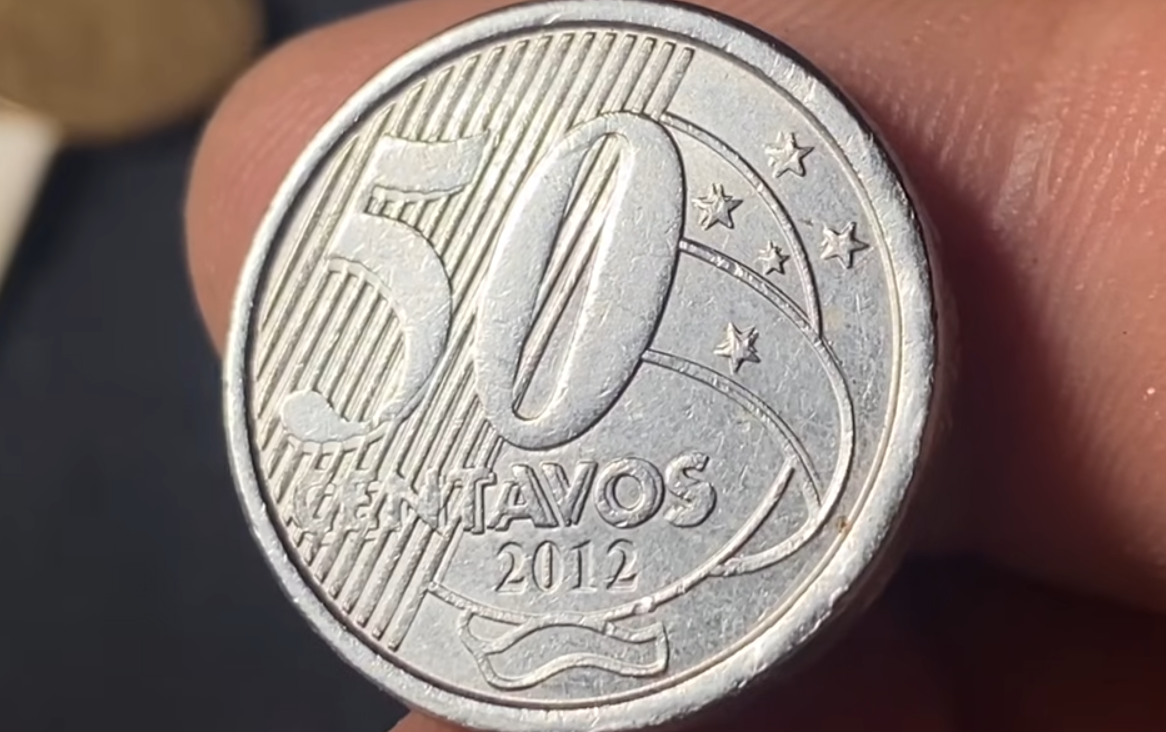 identificando erro matriz duplicada 50 centavos 2012 Macro de moeda de 50 centavos de 2012, focando no reverso onde os números e estrelas apresentam um contorno duplicado, conhecido como matriz de cunho duplicado.