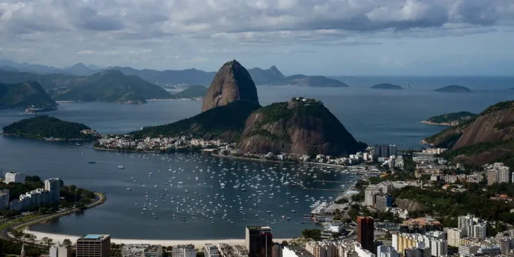 Vista panorâmica da Baía da Guanabara com o Pão de Açúcar e várias embarcações no mar do Rio de Janeiro.