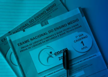 Cadernos do Exame Nacional do Ensino Médio ENEM com caneta sobre mesa azul