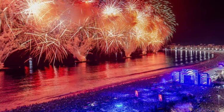 Queima de fogos no Réveillon com milhares de pessoas reunidas à beira-mar durante celebração de Ano Novo