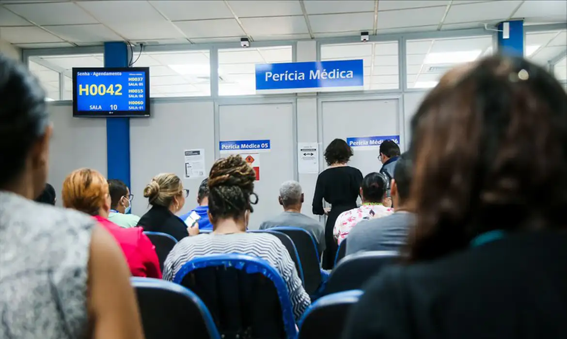 Pessoas aguardando atendimento para realização de perícia médica em agência, representando o funcionamento do mutirão presencial e remoto.