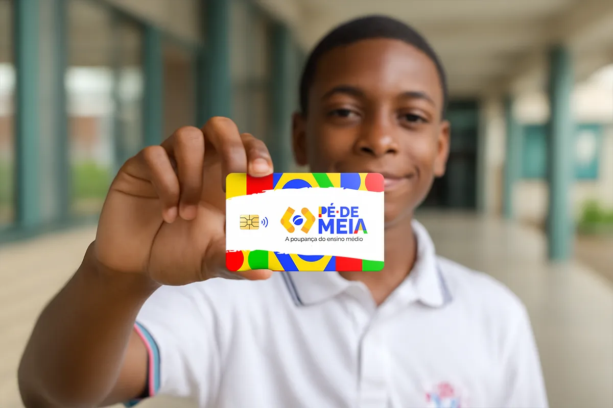Estudante segurando o cartão do programa Pé-de-Meia, destinado a alunos do ensino médio público.