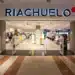 Loja da Riachuelo no shopping, com diversas roupas expostas e promoções visíveis.
